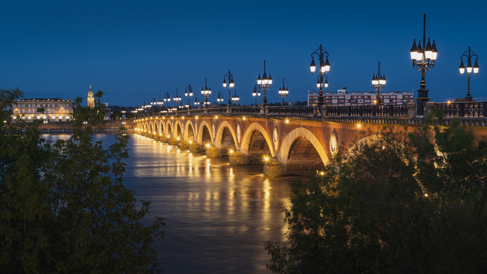 Pont de Pierre de Bordeaux illumine la nuit sur la Garonne - service de chauffeur prive Bordeaux Privilege